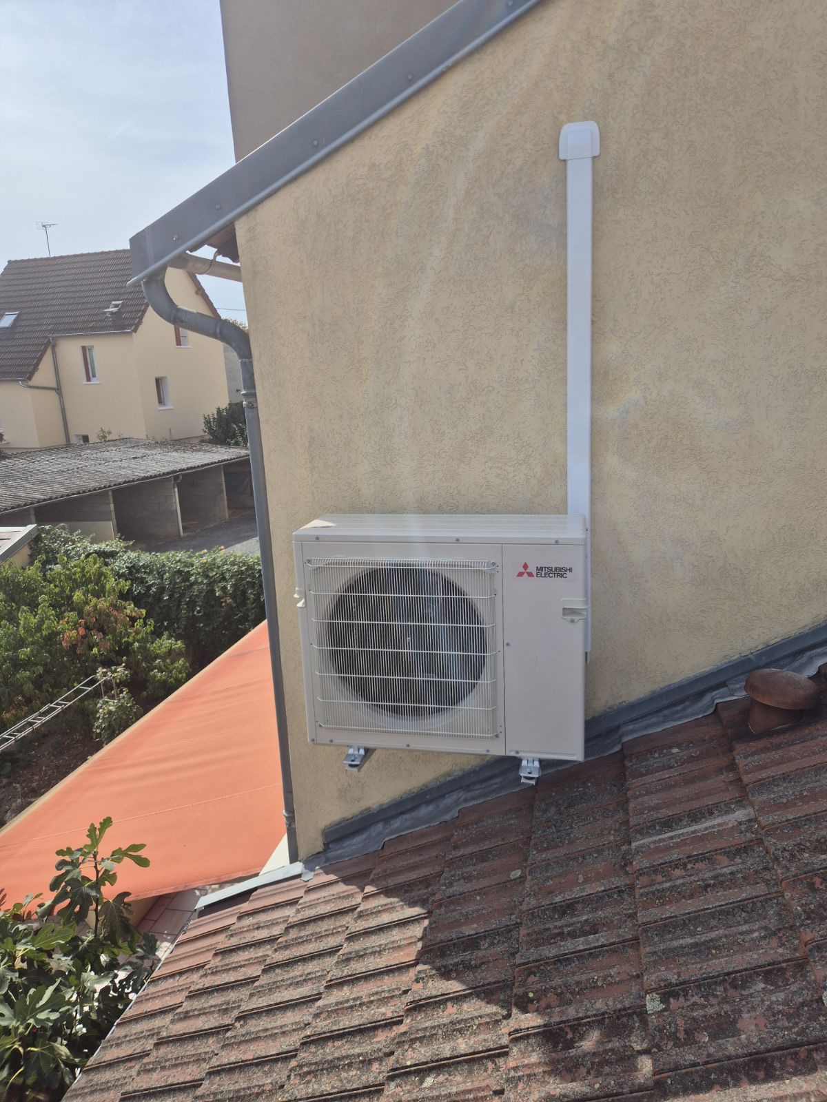 Unité extérieure Mitsubishi Electric MXZ-2F53VFHZ3 posée sur consoles murales au-dessus d'une toiture à Cusset
